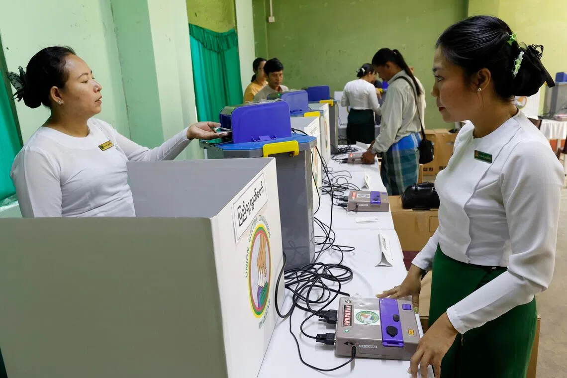 Myanmar electoral officials set up electronic voting machines at a polling station in Yangon, Myanmar, one day before the start of the third election phase.
