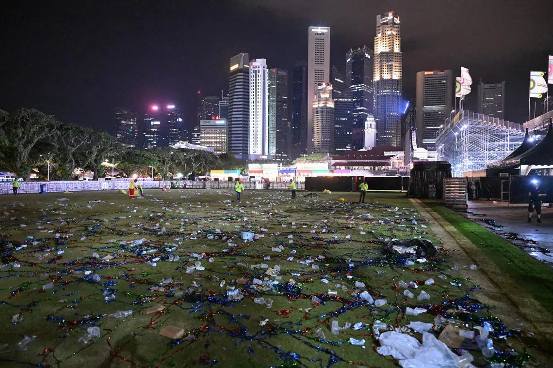 Plastic cups, food packaging and confetti were among the pile of trash left by some of the 65,000 concertgoers after the Robbie Williams concert at The Padang on Sep 18, 2023. Cleaners began to clear the trash about 10 minutes after the concert ended past midnight. It took slightly more than an hour for the trash to be collected into smaller piles and bagged. Rubbish bins could be found around the venue but were mostly full.