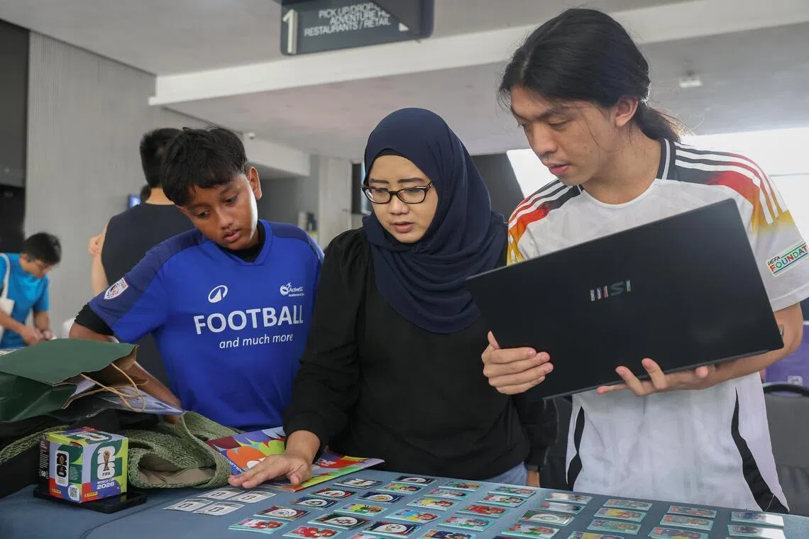 Nanyang Polytechnic aerospace engineering student Lucas Leo (right) discussing a sticker trade with Mohammed Elmaan Mohammed Ezaad (left) and his mother Julie Katherina Abdul Samad.