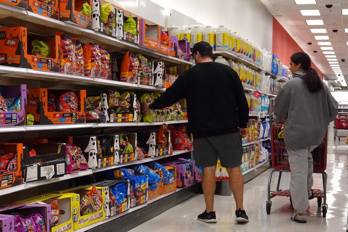 Customers shop at a Target store in California on Oct 30. If inflation resurges, a constrained Fed may keep rates from falling.