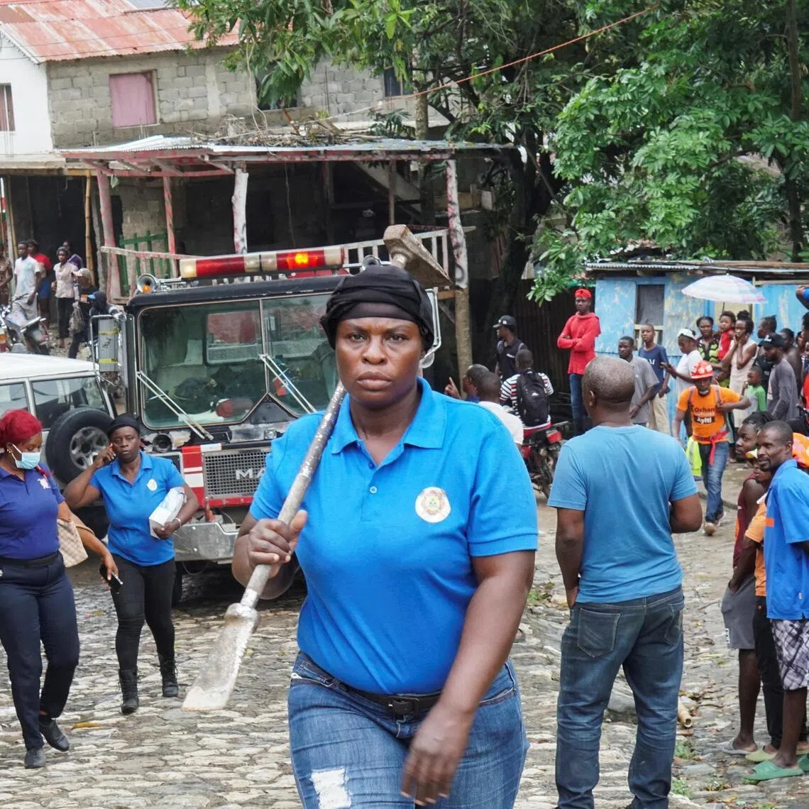 A rescue worker carries a tool at the site after Haiti's Civil Protection for the Nord Department said a stampede killed several people at the Laferriere Citadel.
