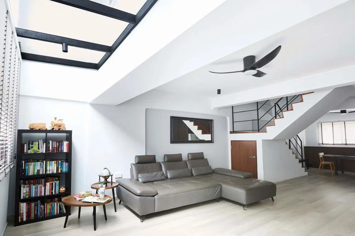 A glass panel above the living room lets natural light into the space.