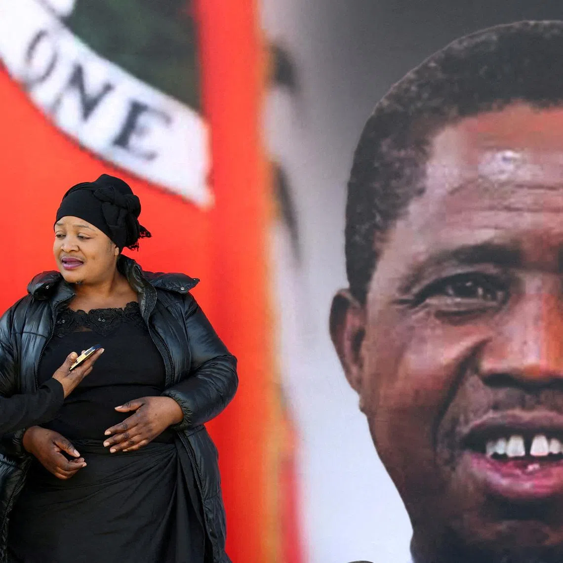 FILE PHOTO: Mourners gather in front of a banner ahead of the funeral of Zambia's former President Edgar Lungu, who died on June 5 while receiving treatment for an undisclosed illness in a South African hospital, before a church service at the Cathedral of Christ the King, and a private burial, in Hillbrow, Johannesburg June 25, 2025. REUTERS/Siphiwe Sibeko/File Photo