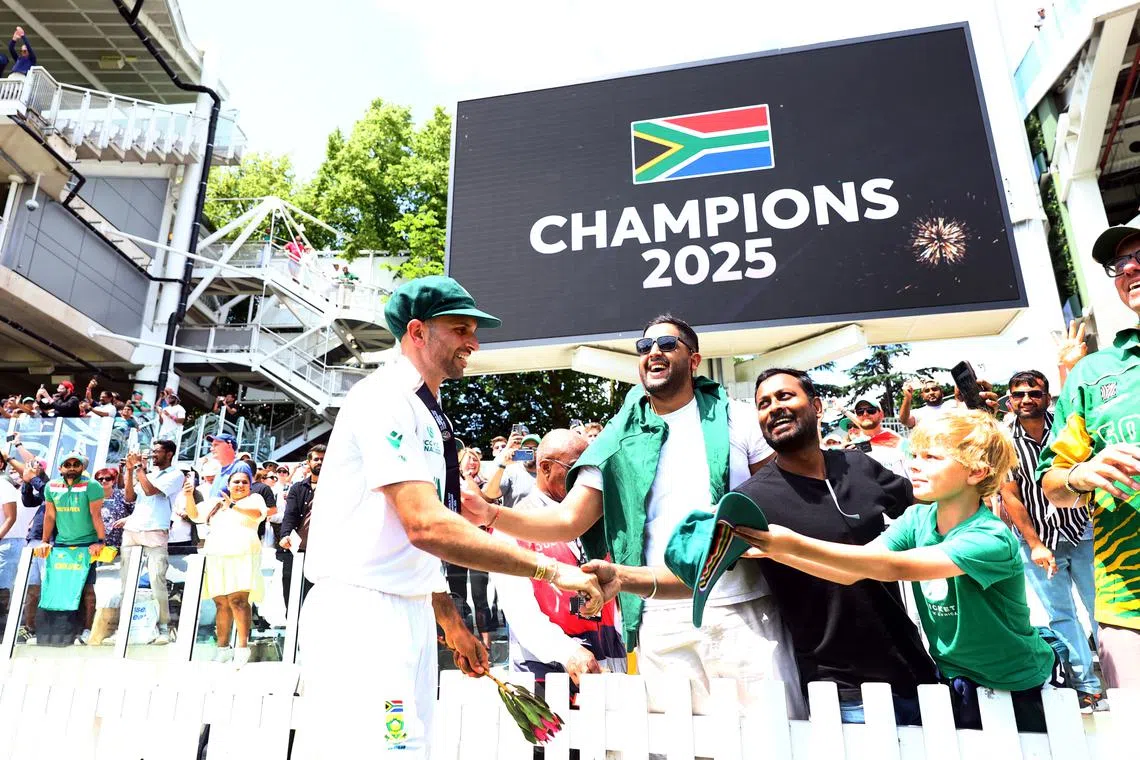 Cricket - 2025 ICC World Test Championship Final - South Africa v Australia - Lord's Cricket Ground, London, Britain - June 14, 2025 South Africa's Keshav Maharaj shakes hands with fans in the stands as a giant screen displays the message of 'Champions 2025' after South Africa won the ICC World Test Championship final Action Images via Reuters/Andrew Boyers