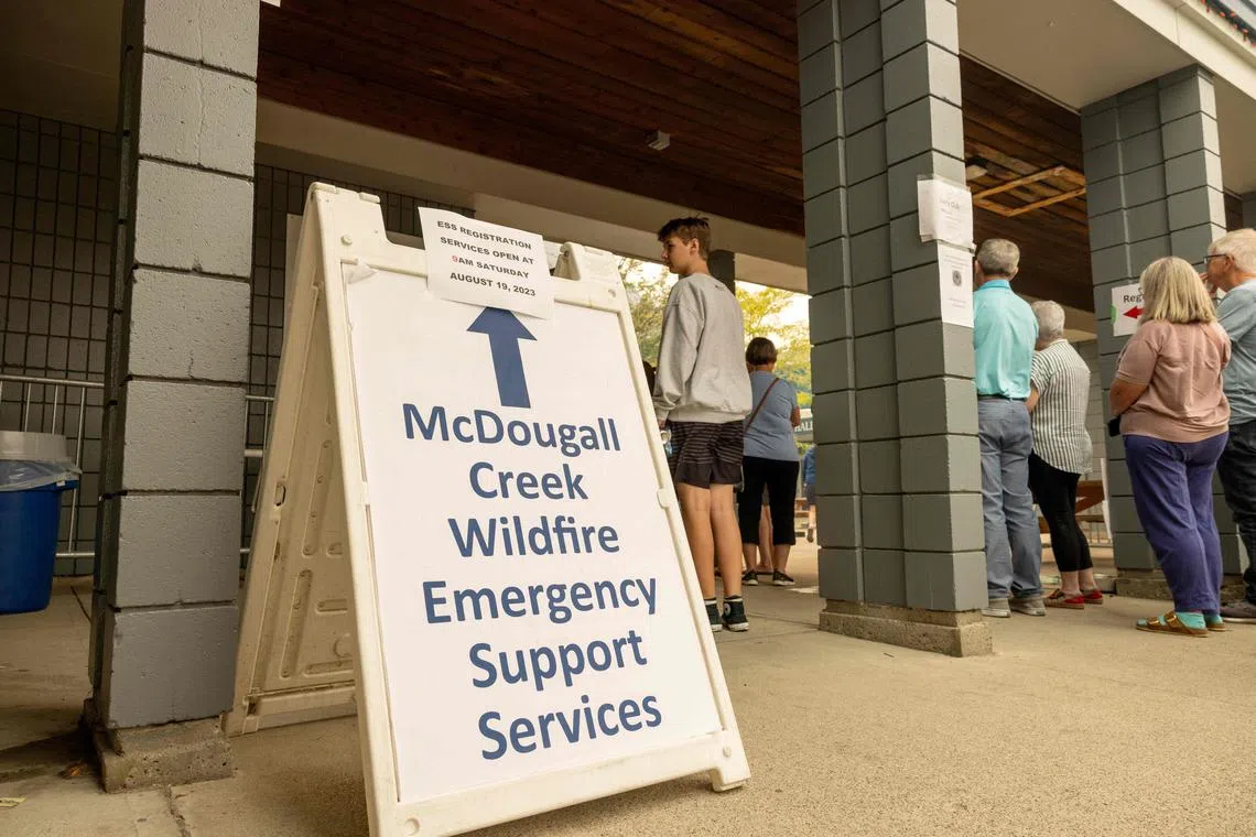 Evacuees from the McDougall Creek wildfire gather outsisde a community centre in West Kelowna, British Columbia.