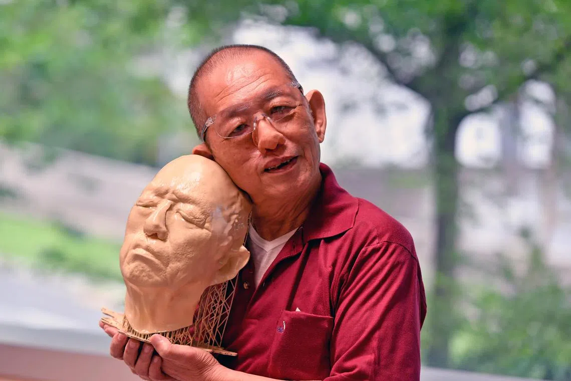 Mr J. F. Lian, 73, wearing his new 3D printed prosthetic nose and holding a 3D printed replica of his face that was recreated from pre-operation CT scans. Mr Lian, a retiree, had most of his external nose removed after radiography failed to fully treat a tumour there.