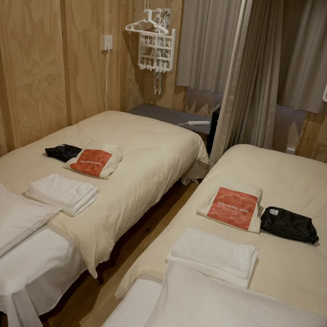 Beds and household goods are prepared inside wooden container-style huts built to house athletes at Athletes Plaza of Aichi-Nagoya Asian Games 2026 in Nagoya, central Japan, September 27, 2026.  REUTERS/Irene Wang