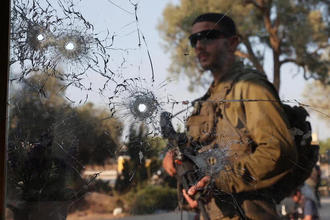 An Israeli soldier walks in Be'eri kibbutz, in the aftermath of a mass infiltration of Israel by Hamas gunmen from the Gaza Strip.