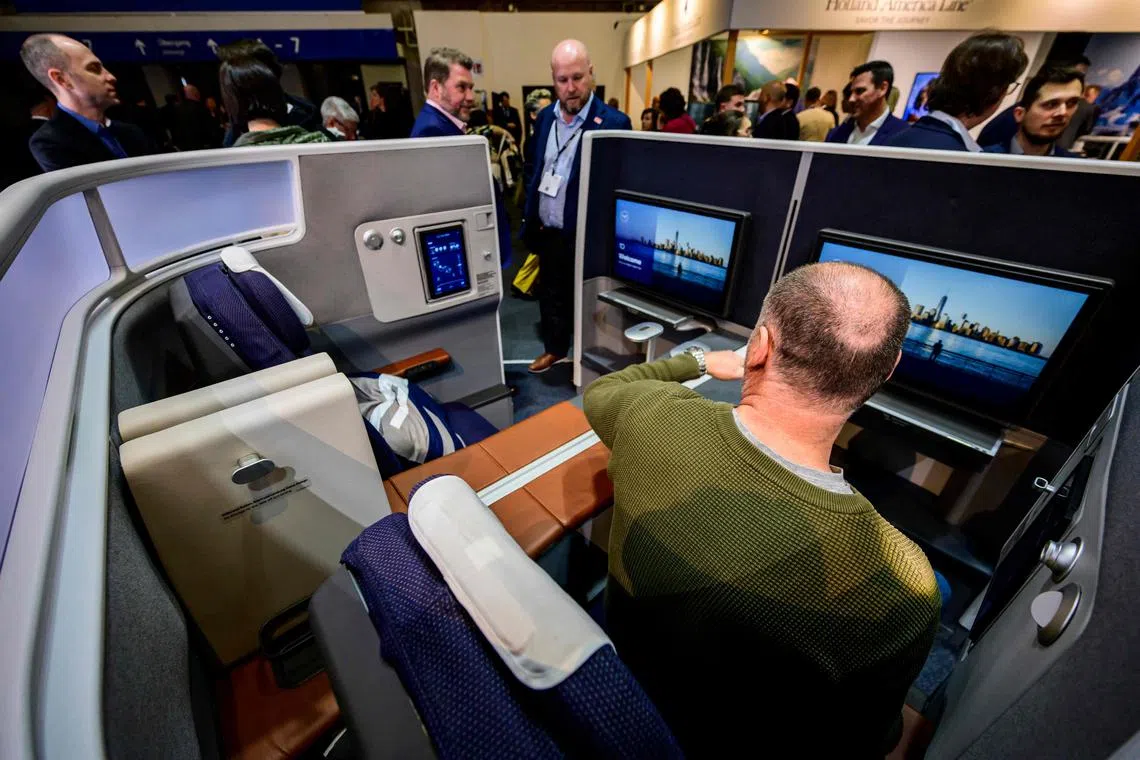 A visitor sits in a Lufthansa mock-up business class cabin at the International Tourism Trade Fair in Berlin on March 8, 2023. 