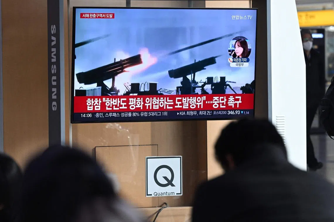 People watching a news broadcast with file footage of North Korea's artillery firing, at a railway station in Seoul on Jan 5. 