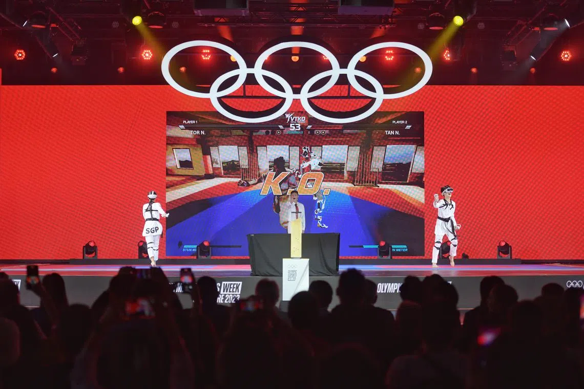 Singapore's Nigel Tan (right) celebrating after beating compatriot Natalie Tor in the grand final of the Olympic Esports Week taekwondo competition.