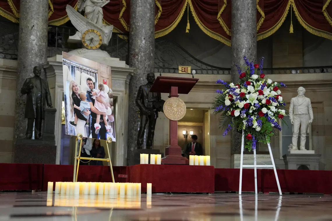 FILE PHOTO: Candles and flowers are placed near an image of conservative activist Charlie Kirk with his family, during a vigil for him in Statuary Hall of the U.S. Capitol in Washington, D.C., U.S., September 15, 2025. REUTERS/Ken Cedeno/File Photo
