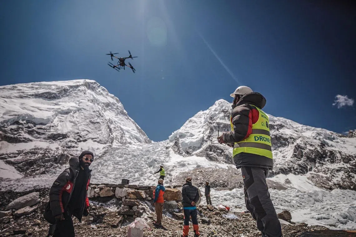 A man operates a heavy-lift drone to clear trash dumped at the Everest Base Camp.  
