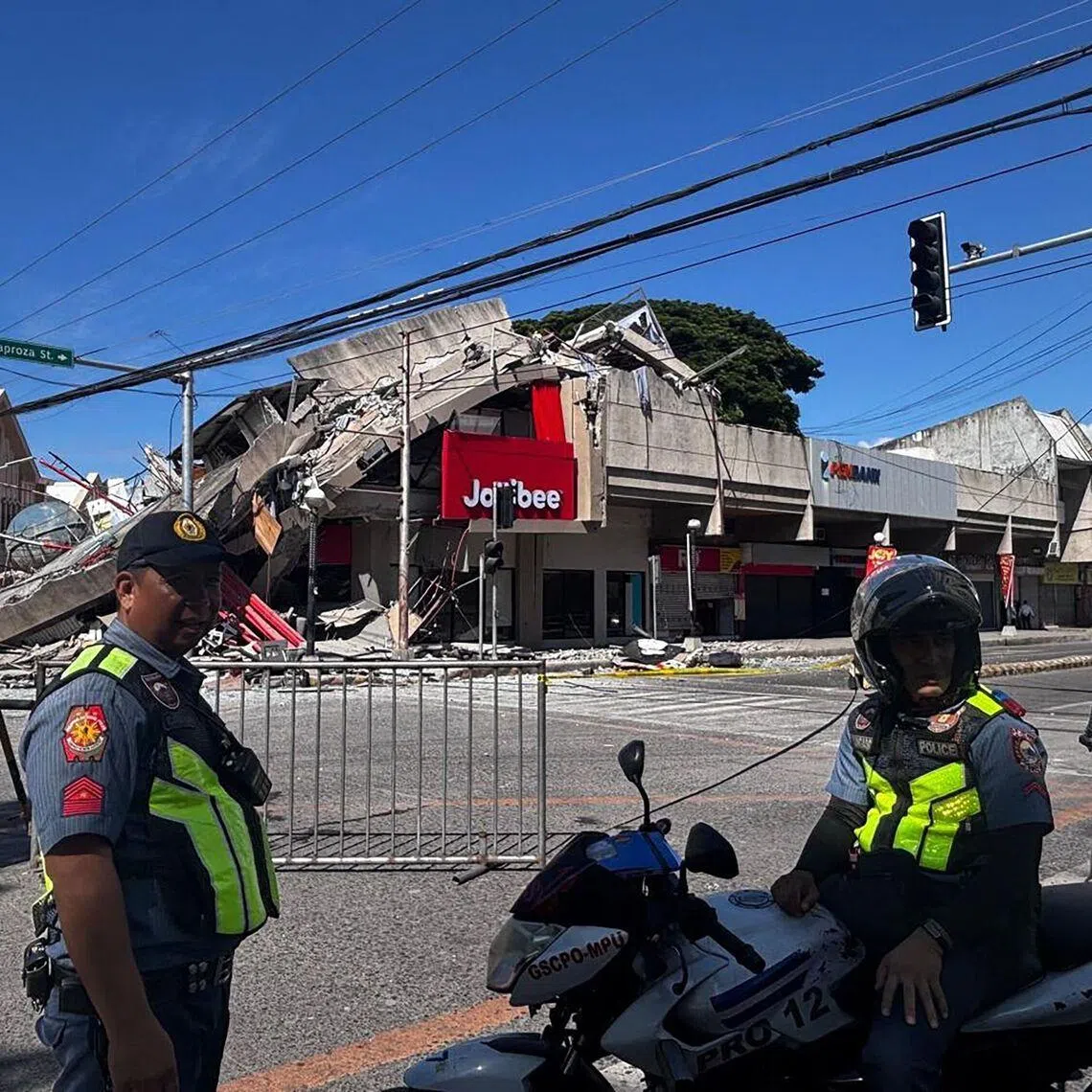 Police gather in front of a collapsed Jollibee fast food restaurant after an 7.8 magnitude earthquake in General Santos City on June 8.