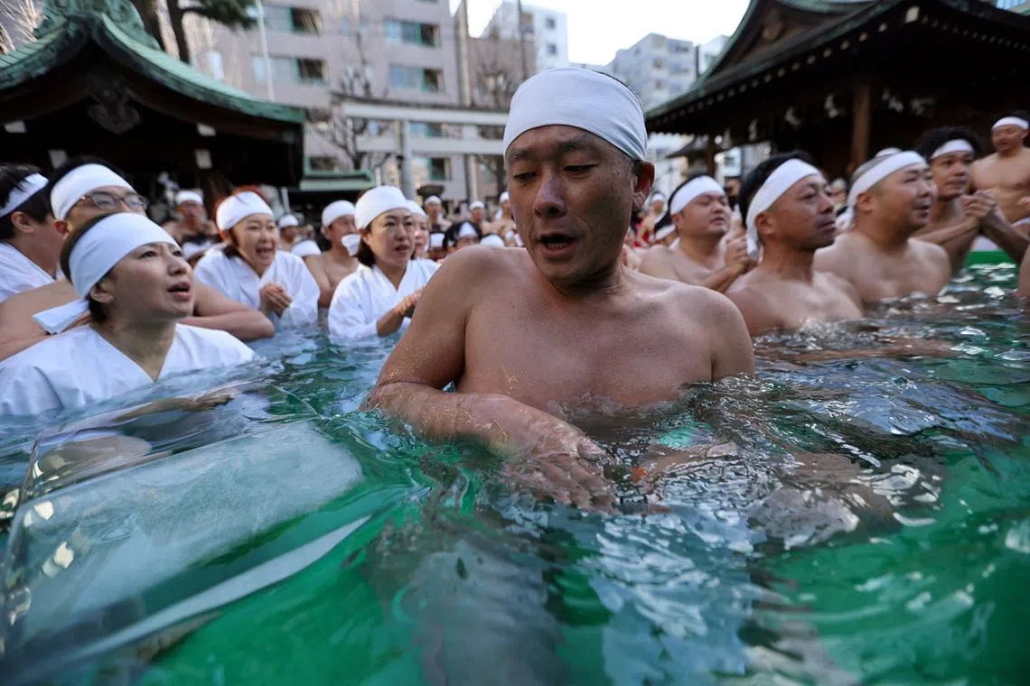 A participant reacting to the ice touching his skin during an ice-cold bath, as people take part in the ceremony to purify their souls and to pray for the New Year, at the Teppozu Inari shrine, in Tokyo, Japan, Jan 11, 2026. 
