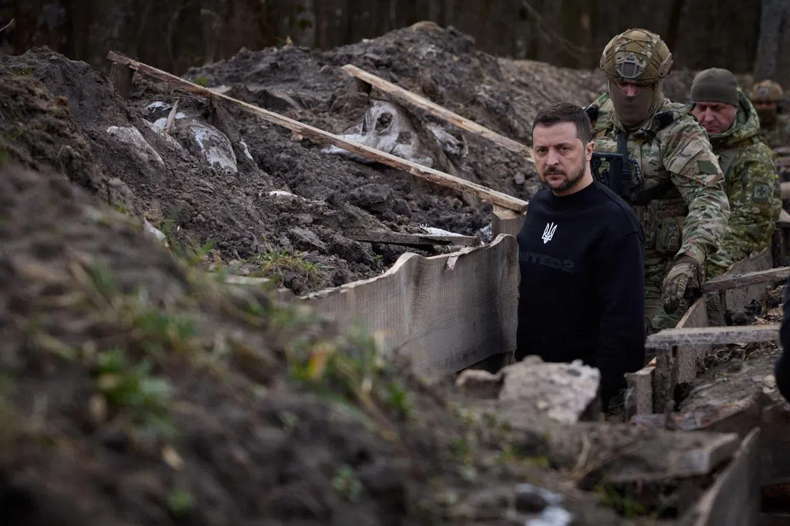 Ukrainian President Volodymyr Zelensky walks along trenches with border guard officers, as he inspects  the state border with the Russian Federation, in Ukraine's Sumy region.