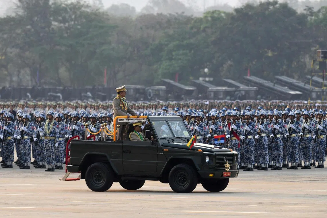 Myanmar's Chief Senior General Min Aung Hlaing stands in a vehicle as he attends a ceremony to mark the country's 78th Armed Forces Day in Naypyidaw on March 27, 2023. (Photo by AFP)