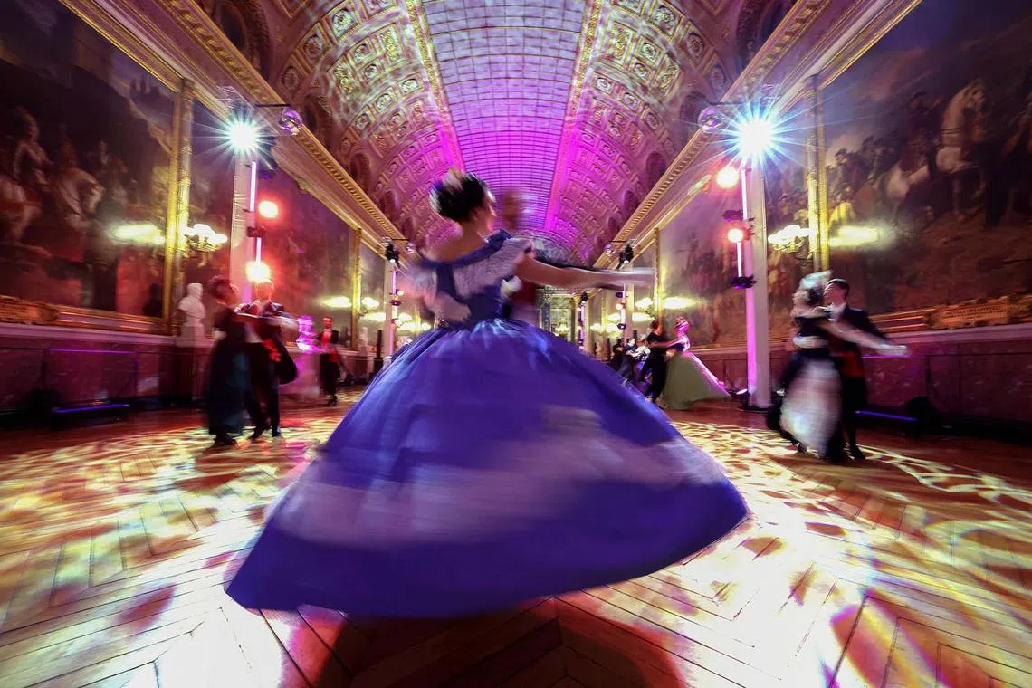 TOPSHOT - Guests dressed in period costumes take part in the ball of the century at the Chateau de Versailles, on December 11, 2023. The ball of the century hosted guests to mark the 100th year of its restauration with a dance journey from the end of the 19th century to the start of the 20th century. (Photo by Emmanuel DUNAND / AFP)