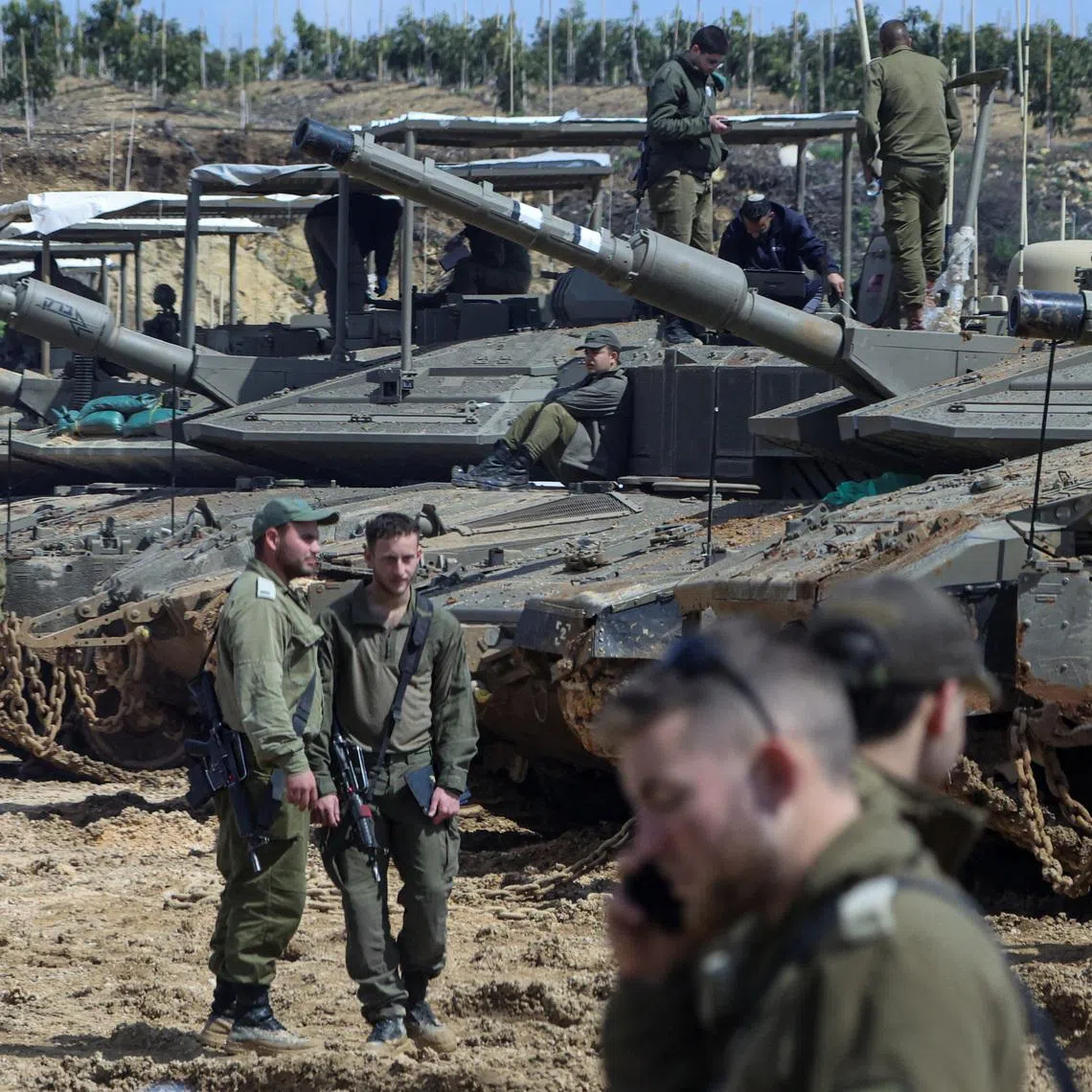 Israeli soldiers stand next to tanks near the Israeli side of the border with Lebanon, amid escalation between Iran-backed Hezbollah and Israel and the U.S.-Israeli conflict with Iran, in northern Israel, March 23, 2026.
