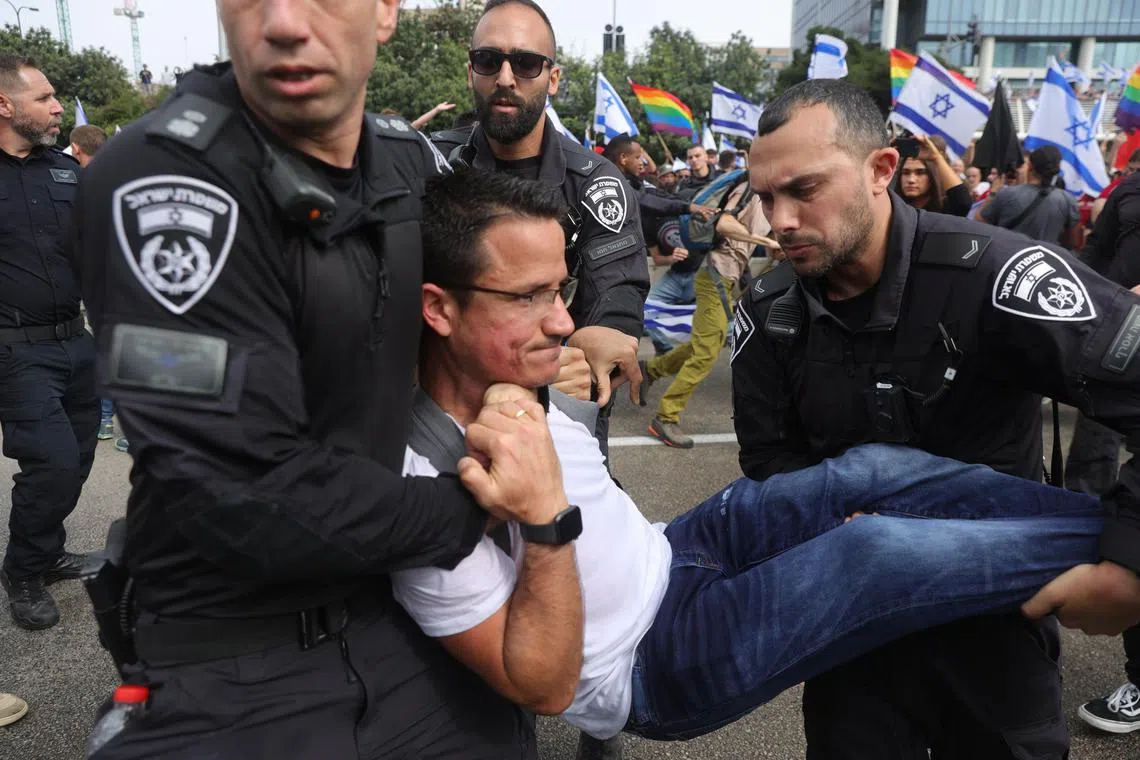 Police detain a protester blocking the Ayalon Highway, during a rally in Tel Aviv, on March 23, 2023.