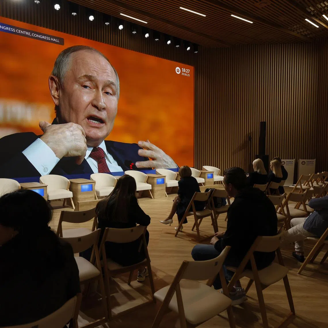 Participants watch Russian President Vladimir Putin's speech on a TV screen at the 28th Saint Petersburg International Economic Forum on June 20.