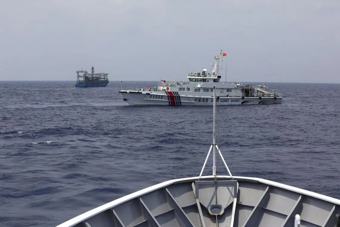 FILE PHOTO: A Chinese Coast Guard ship is seen blocking the direction of a Philippine Coast Guard ship conducting a resupply mission for Filipino troops stationed at a grounded warship in the South China Sea, October 4, 2023. REUTERS/Adrian Portugal/File photo