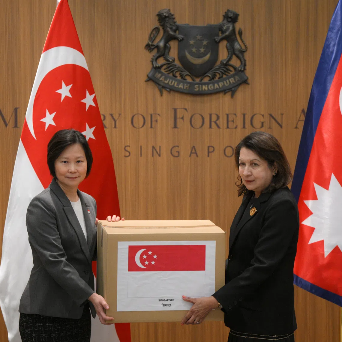 Minister of State for Foreign Affairs Gan Siow Huang (left) symbolically hands over a humanitarian assistance (HA) package to Nepal’s honorary consul in Singapore, Helen Campos, at the Ministry of Foreign Affairs (MFA) in Tanglin, on Sept 4.