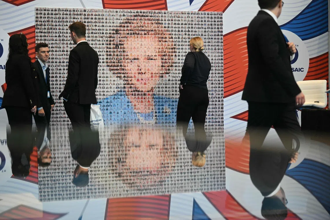 Delegates looking at a montage creating an image of former Conservative prime minister Margaret Thatcher, on the third day of the annual Conservative Party conference in Manchester, north-west England, on Oct 7, 2025.