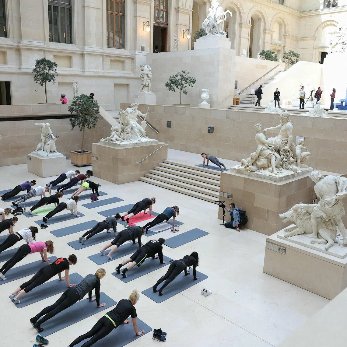 Dancers take part in a rehearsal of "Les visites sportives" by artist and choreographer Mehdi Kerkouche in the Cour Marly at the Louvre Museum in Paris on April 23, 2024. 