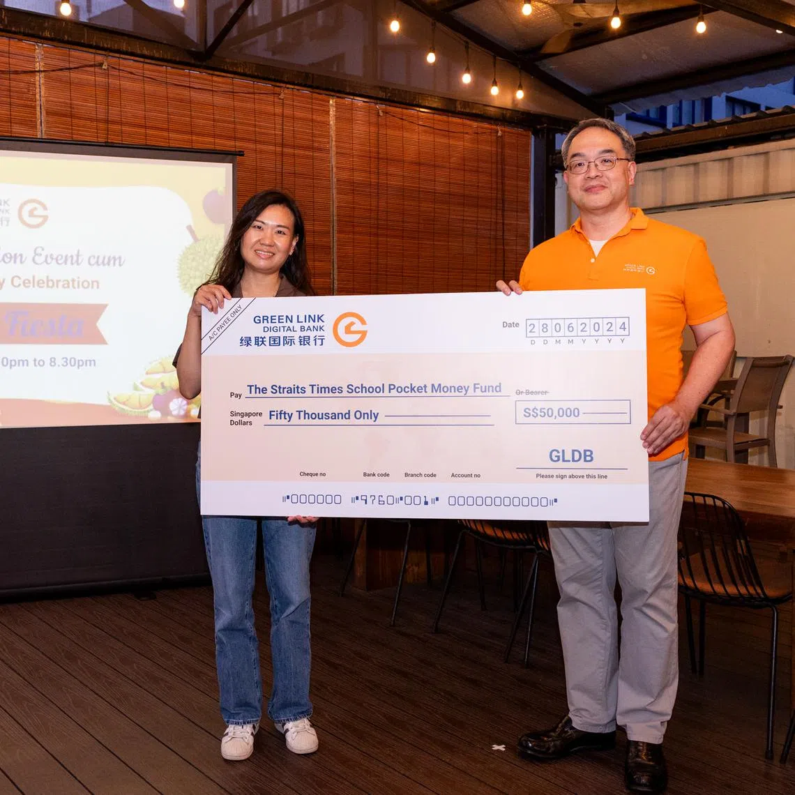 Green Link Digital Bank chief executive officer Melvin Teo (right) presenting a mock cheque to STSPMF general manager Lau Hui Ling on June 28.