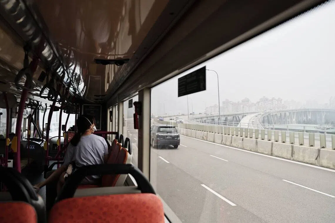 A passenger looking out from the bus at the haze-shrouded Marina area at about noon on Oct 17.