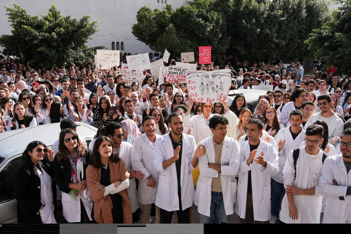 Young doctors gather and hold signs during a protest as thousands went on strike across Tunisia on Wednesday, demanding higher pay and warning of an impending collapse of the health system, part of a broader wave of social unrest convulsing the country, in Tunis, Tunisia, November 19, 2025. REUTERS/Jihed Abidellaoui