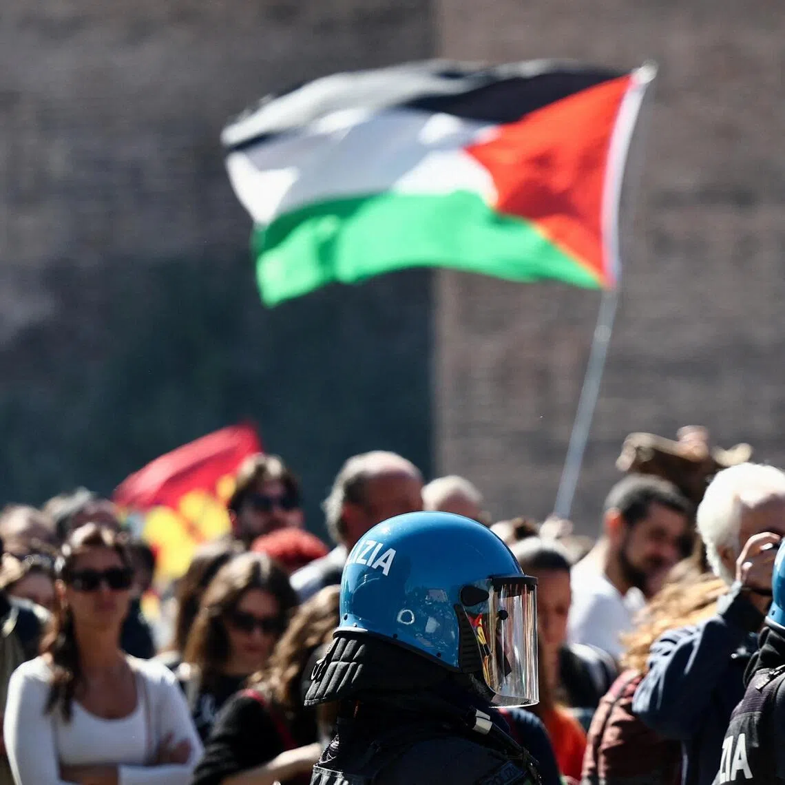 Police stand near pro-Palestinian demonstrators at a protest during a nationwide strike, in Rome, Italy, on Oct 3. 