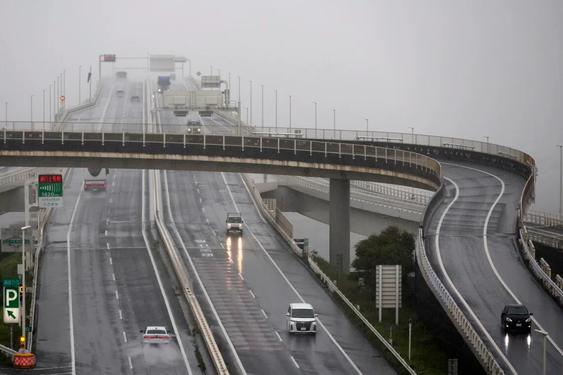 Vehicles drive through heavy rain caused by typhoon Mekkhala at Umihotaru Parking Area in Kisarazu, Chiba prefecture, near Tokyo, on June 27.