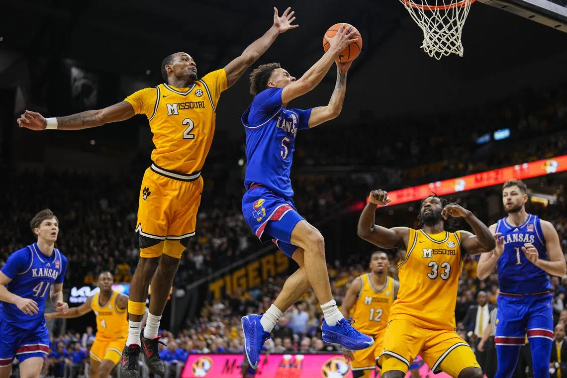 Dec 8, 2024; Columbia, Missouri, USA; Kansas Jayhawks guard Zeke Mayo (5) shoots the ball against Missouri Tigers guard Tamar Bates (2) and center Josh Gray (33) during the first half at Mizzou Arena. Mandatory Credit: Jay Biggerstaff-Imagn Images/ File Photo