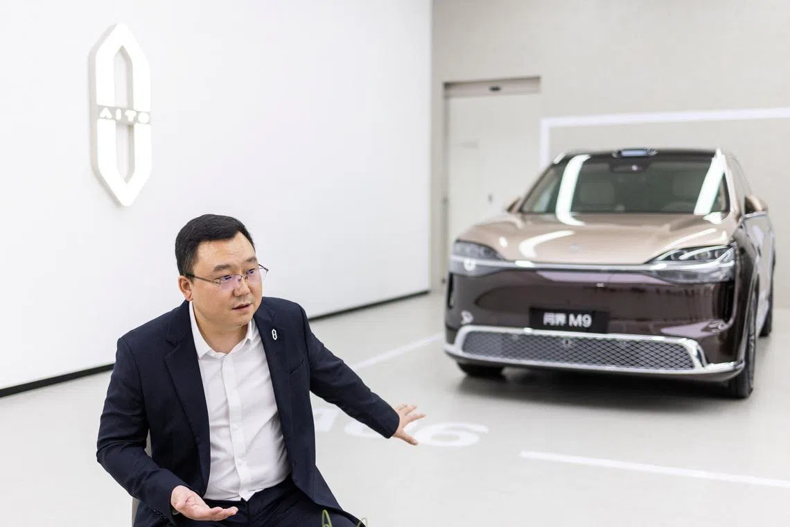AITO Chairman John Zhang speaks next to a newly presented M9 SUV model.