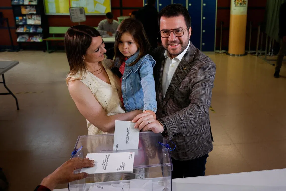 FILE PHOTO: Catalonia's President and Republican Left Party's (ERC) candidate Pere Aragones votes as he stands next to his wife Janina Juli Pujol holding a child during the Catalonia regional elections, in Pineda de Mar, Spain May 12, 2024. REUTERS/Albert Gea/File Photo