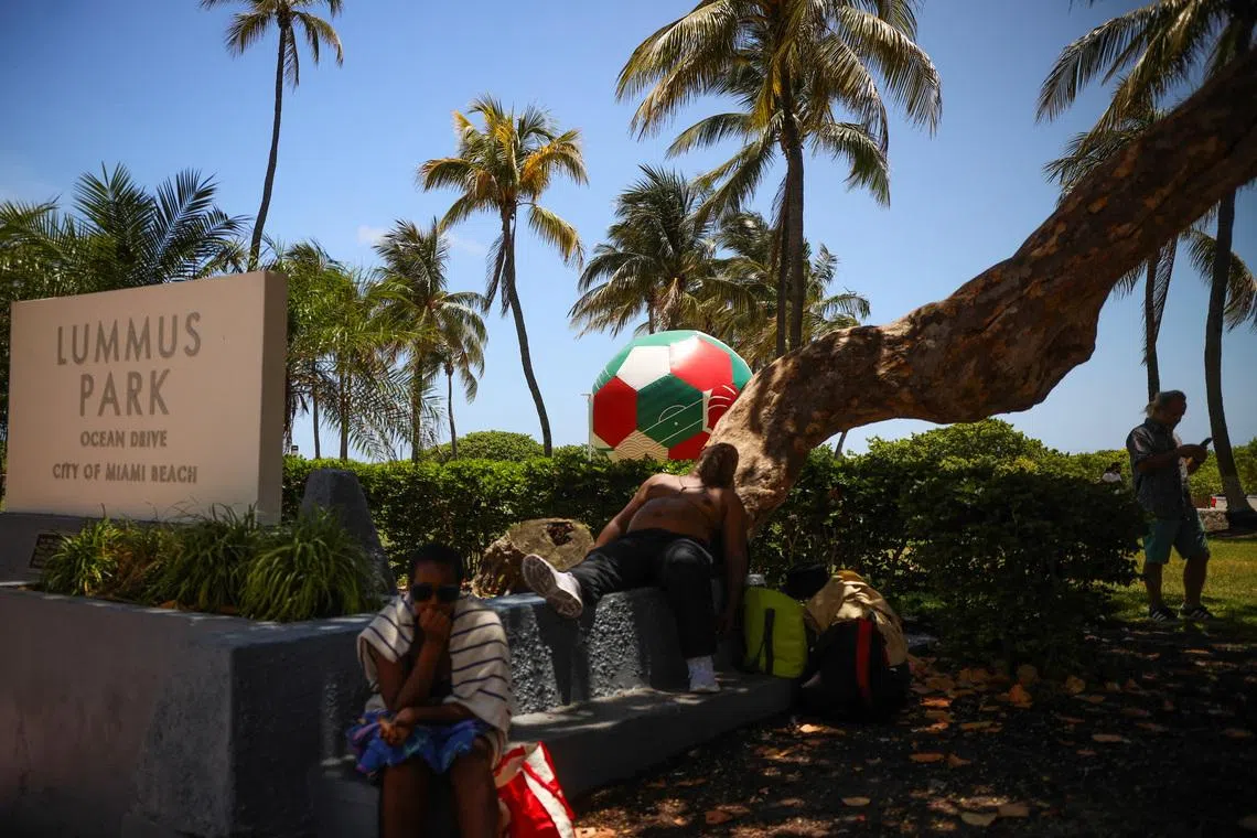 An inflatable soccer ball sits on Lummus Park as a man sleeps under a shaded tree  amid a heat advisory in Miami Beach, Florida, U.S., June 17, 2026. REUTERS/Maria Alejandra Cardona