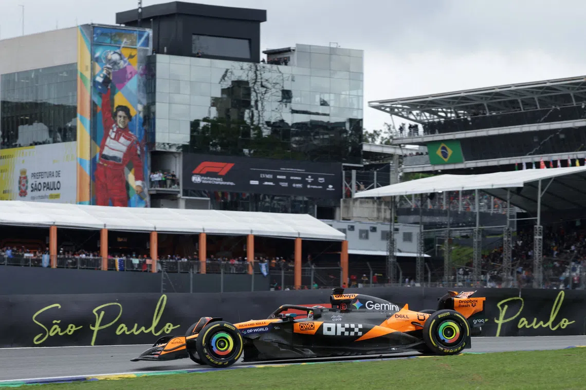 Formula One F1 - Sao Paulo Grand Prix - Autodromo Jose Carlos Pace, Sao Paulo, Brazil - November 9, 2025 McLaren's Oscar Piastri in action as a mural of former F1 driver Ayrton Senna is seen during the race REUTERS/Ricardo Moraes