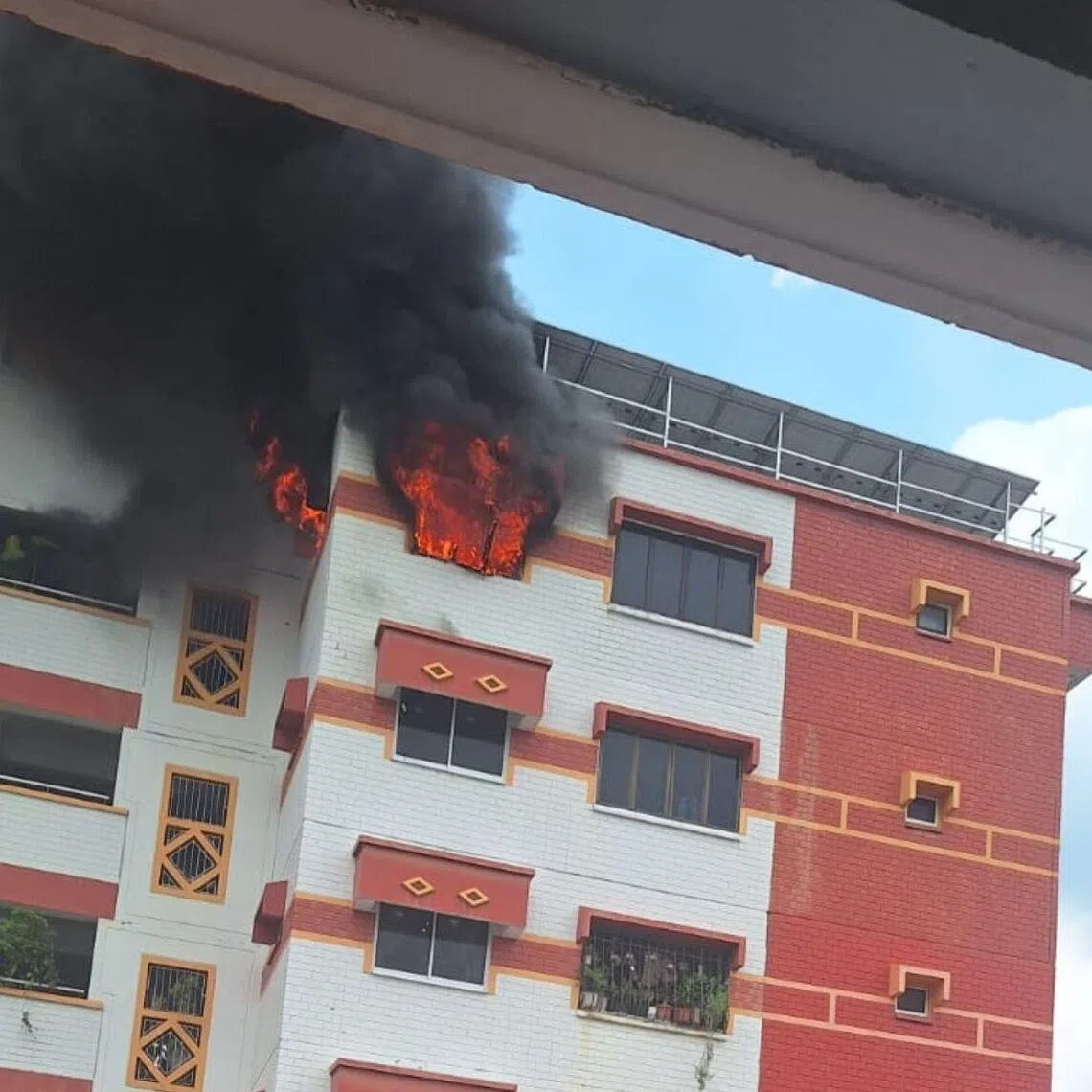Black smoke can be seen coming out of a top-floor unit in a Choa Chu Kang HDB.