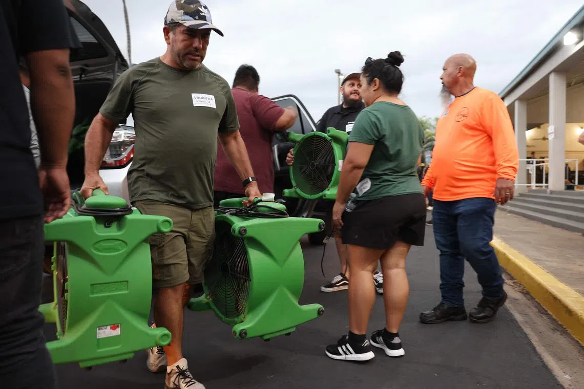Volunteers with King's Cathedral Maui unloading a donation of industrial fans on Aug 10, in Kahului.