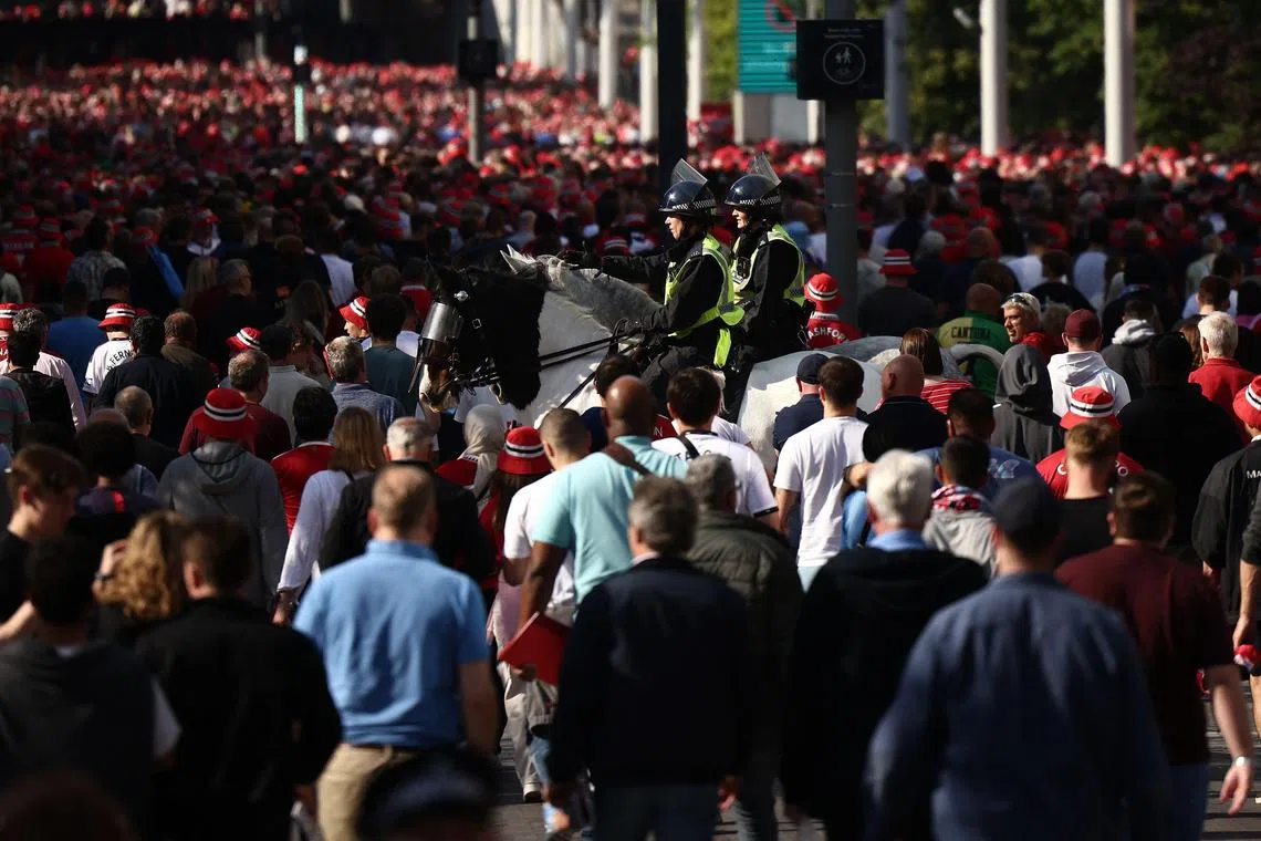 Police officers patrol as fans leave Wembley Stadium in London after the FA Cup final football match on Saturday.