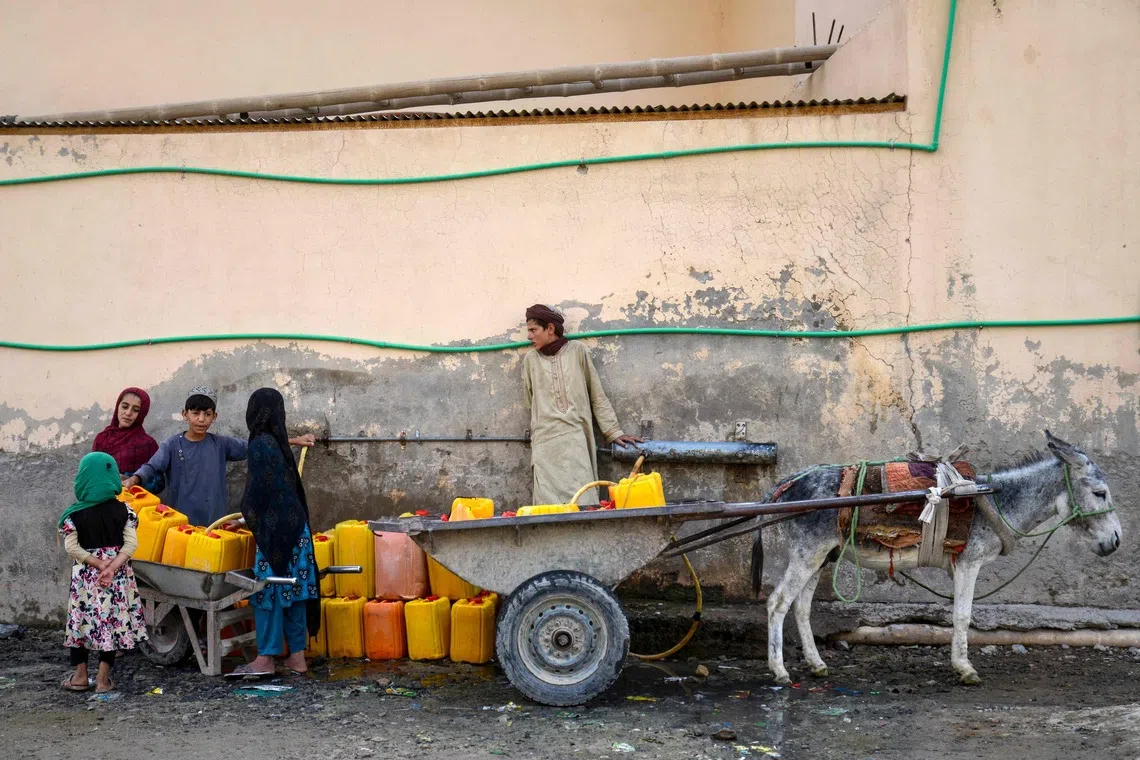 Afghan children fill canisters at a public water tap in the Dand district of Kandahar province on Sept 17.