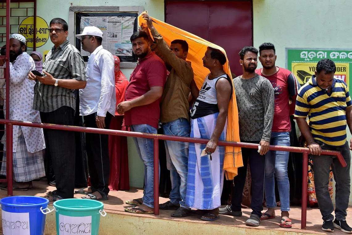 Voters wait in a line outside a polling station during the sixth phase of India's general election, on a hot summer day in Bhubaneswar, India, on May 25.