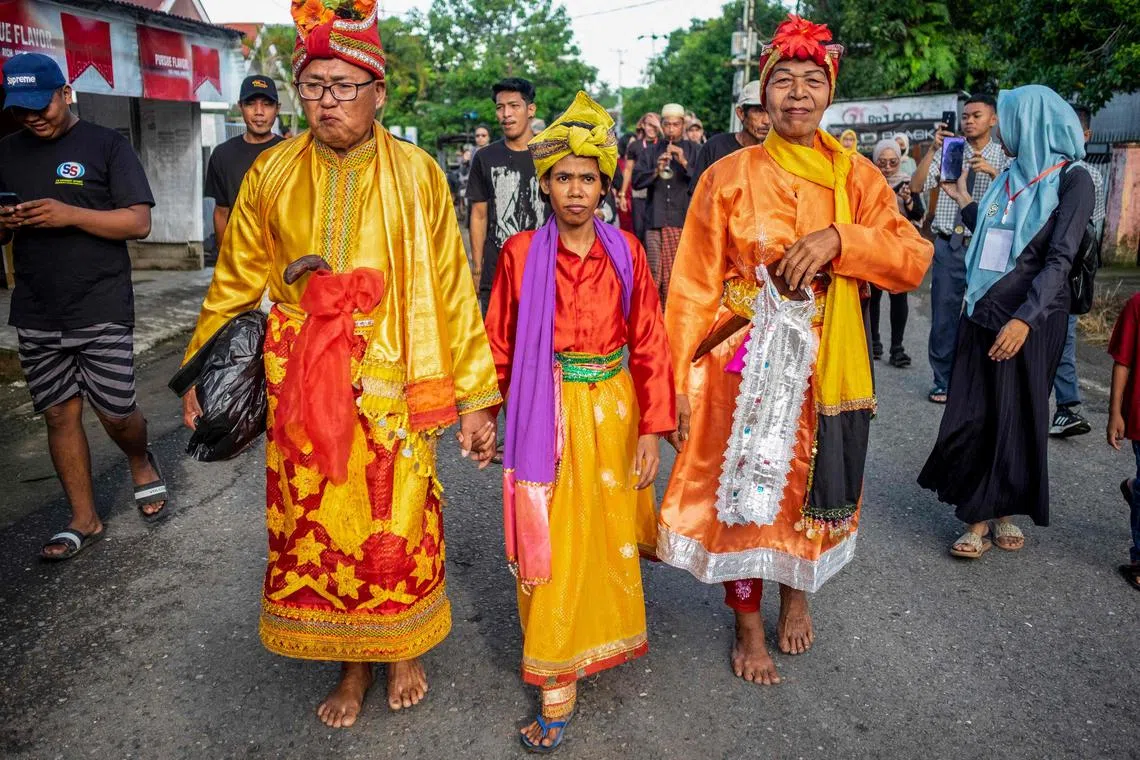 This picture taken on November 16, 2022 shows Bissu, non-binary priests, taking part in a Mappalili ceremony in Pangkajene, South Sulawesi. - The ceremony marks the start of the planting season on the island of Sulawesi, where the androgynous Bissu community to whom they belong once held divine status, but are now fighting against extinction. (Photo by INDRA ABRIYANTO / AFP) / To go with AFP story Indonesia-culture-religion-gender, FOCUS by  Dessy SAGITA