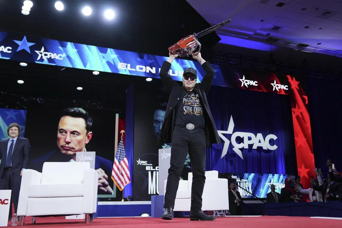 Billionaire Elon Musk on stage with a chainsaw gifted to him by Argentinian President Javier Milei (left), during a US conservative conference on Feb 20.