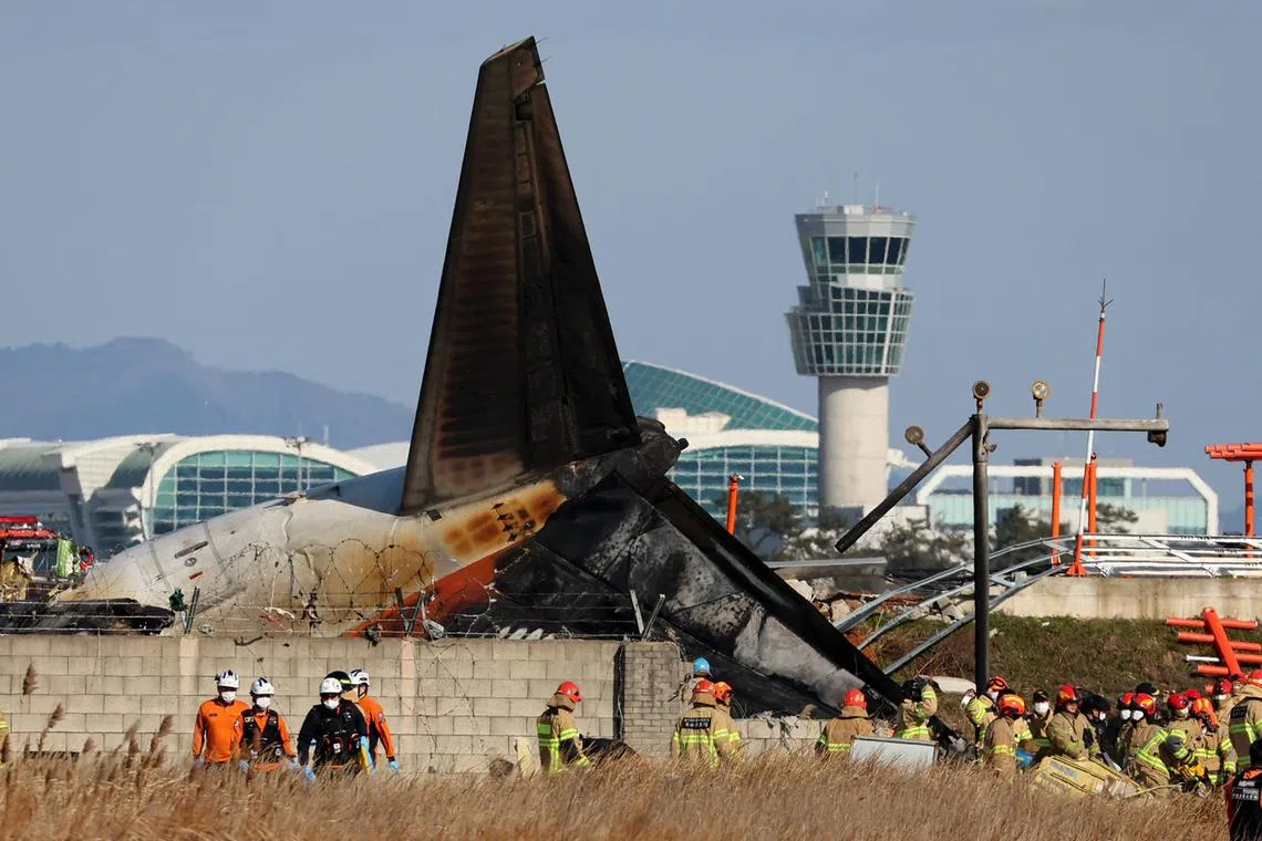 Firefighters and investigators at the scene of the plane crash on Dec 29.