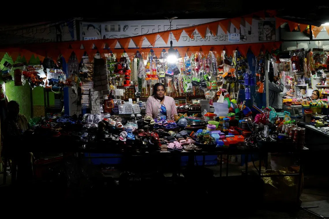 Nayantara Gupta, 28, sits at her shop in a slum in Bhopal, India, February 7, 2024. REUTERS/Anushree Fadnavis
