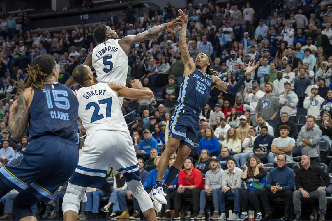 Memphis Grizzlies guard Ja Morant falls back after releasing the game-winning shot over Minnesota Timberwolves guard Anthony Edwards at Target Center. 