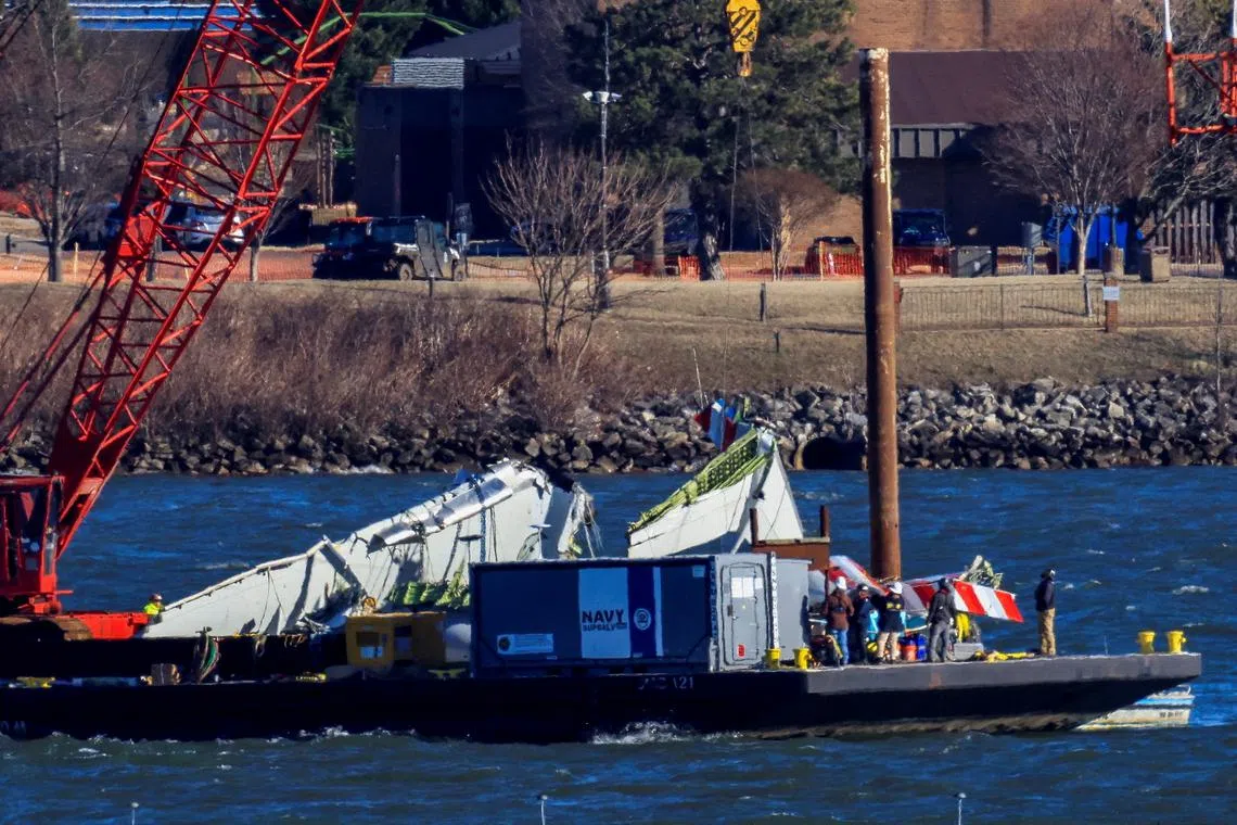 FILE PHOTO: A crane retrieves part of the wreckage from the Potomac River, in the aftermath of the collision of American Eagle flight 5342 and a Black Hawk helicopter that crashed into the river, by the Ronald Reagan Washington National Airport, in Arlington, Virginia, U.S., February 4, 2025.  REUTERS/Eduardo Munoz/File Photo